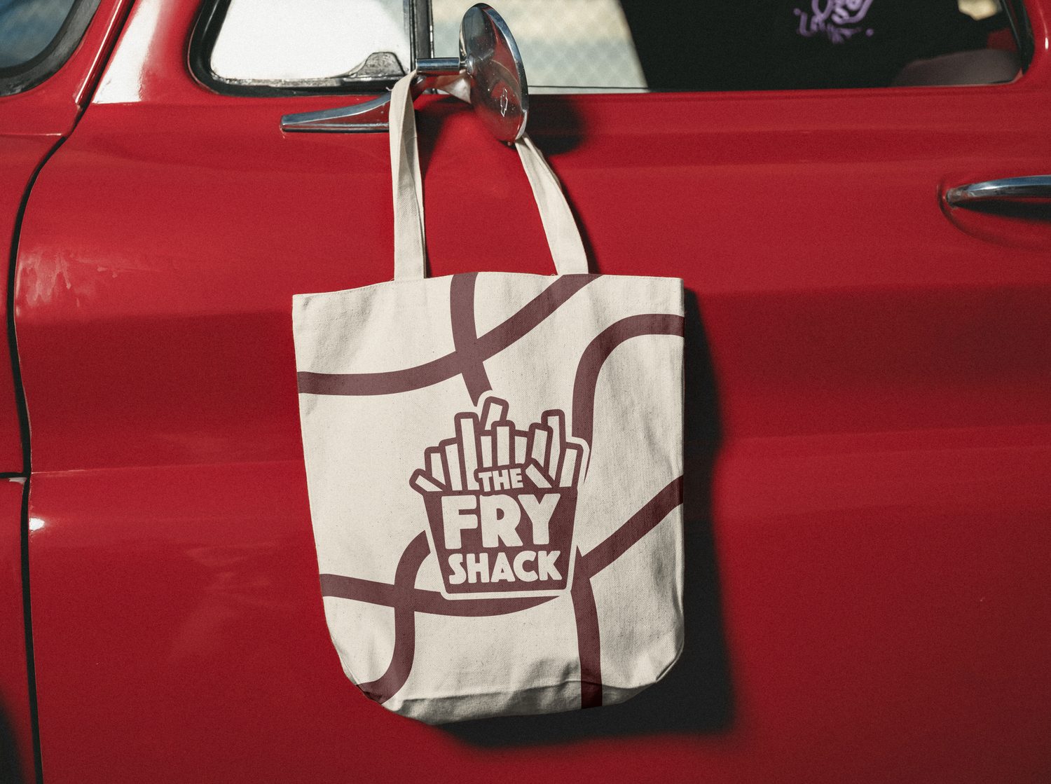 Fry Shack tote bag mockup hanging on a car door